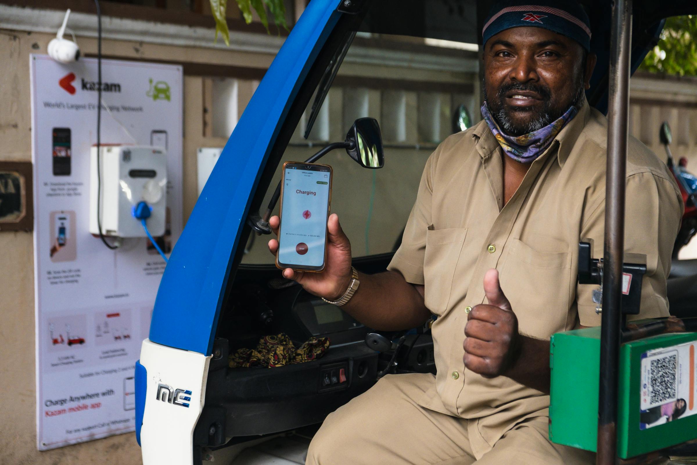 Conductor usando su smartphone en un punto de recarga